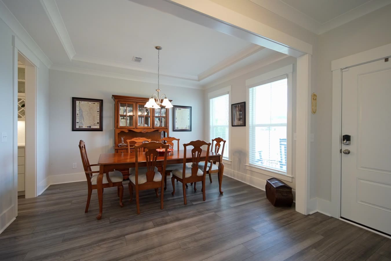 Dining room with a tray ceiling and front windows
